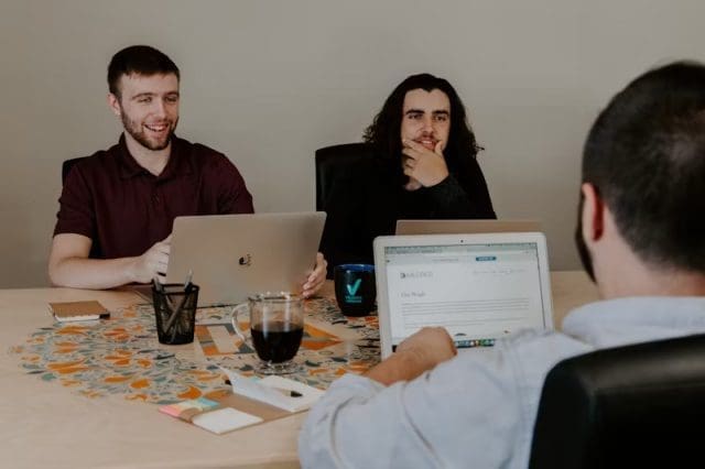 Équipe de travail assises à une table travaillant sur leur ordinateur